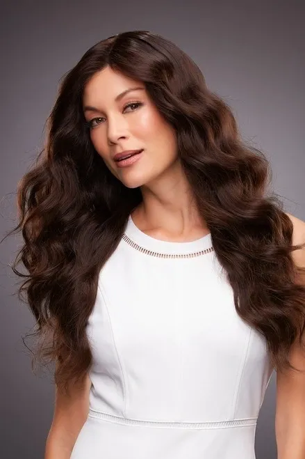 A woman in a white dress with long wavy hair.