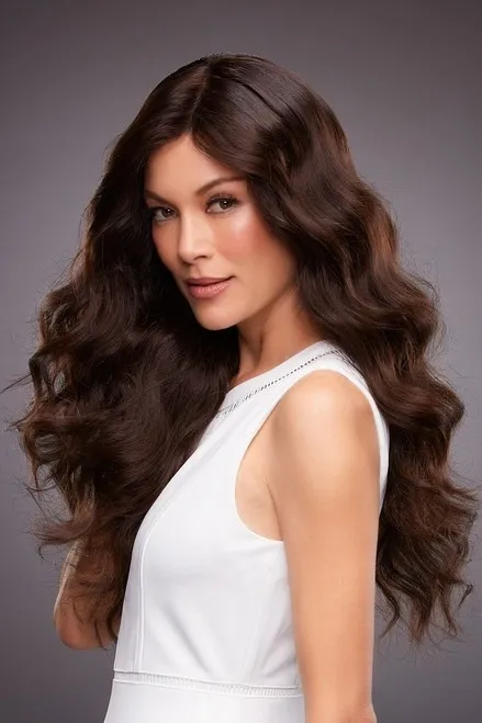 A woman in a white dress with long wavy hair.